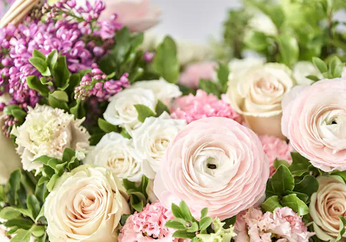 Soft pink and cream roses arranged with greenery, showcasing stunning spring flowers.