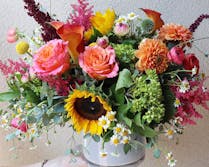 Various flowers, plants and accents atop a wooden workbench